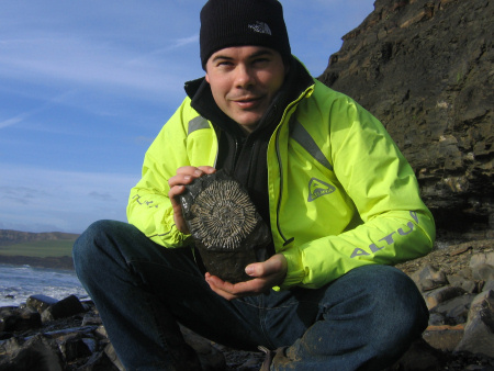 Roy Shepherd holding a fossil Subdichotomoceras websteri ammonite at Kimmeridge